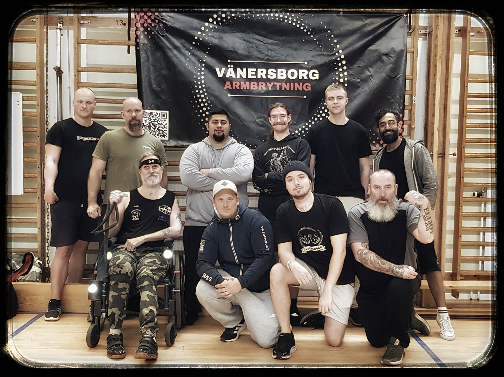 Medlemmar i Vänersborgs Armbrytarklubb samlade framför klubbens banner